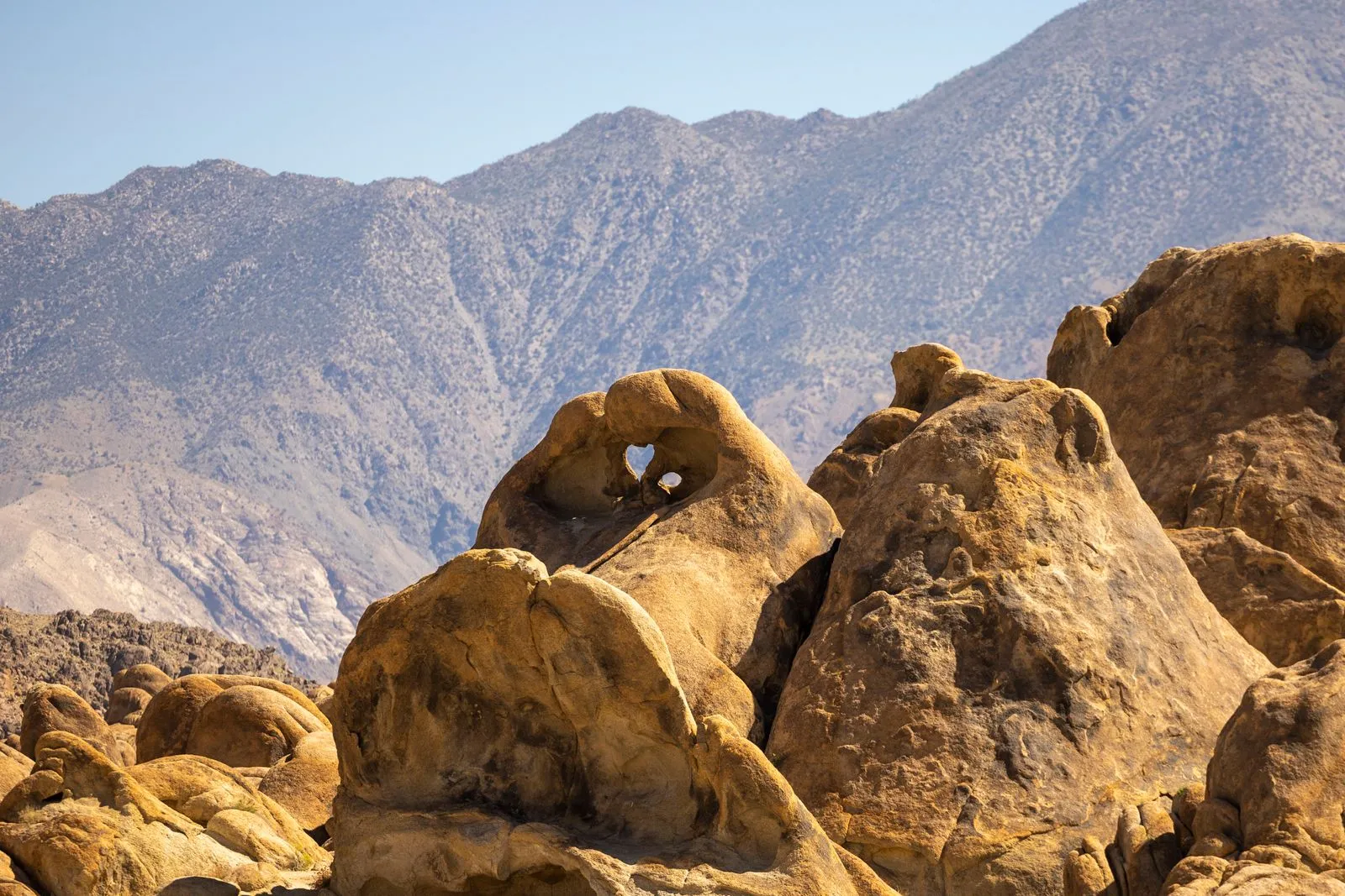 Rounded granite boulders in the Alabama Hills with the eastern Sierra rising behind