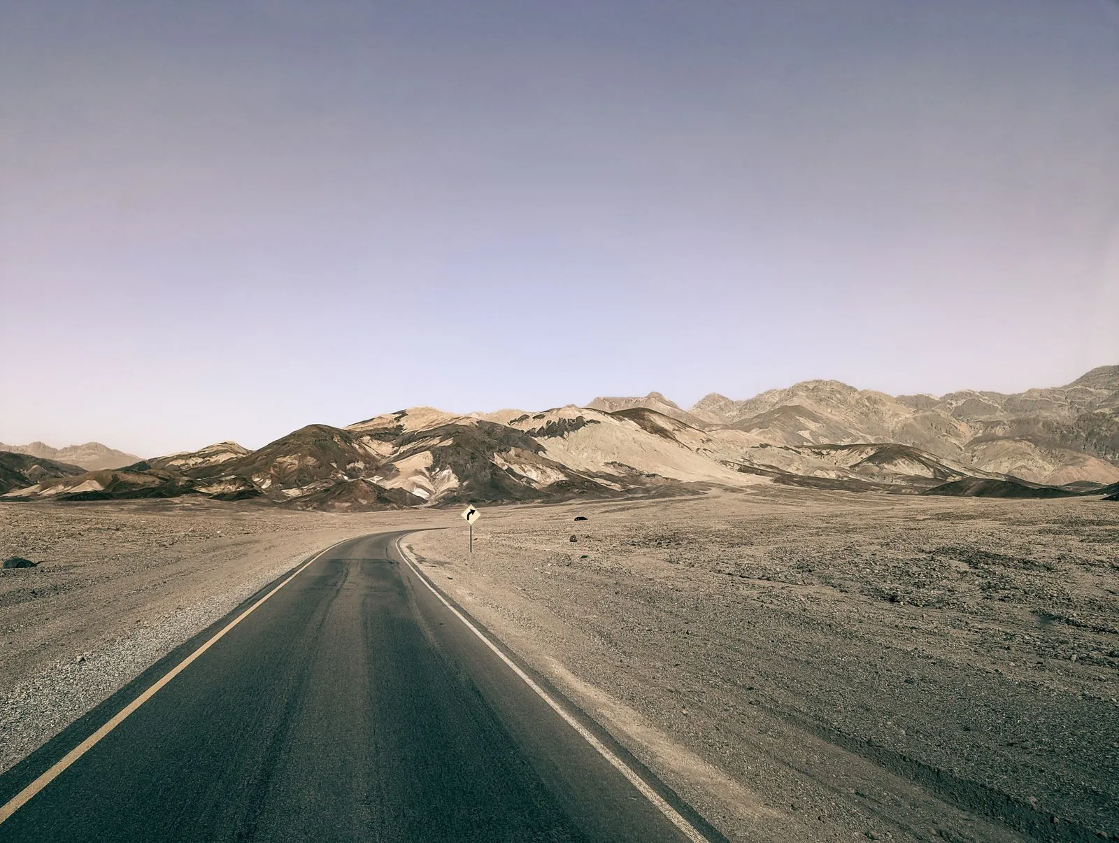 Winding paved road through the barren desert landscape of Death Valley