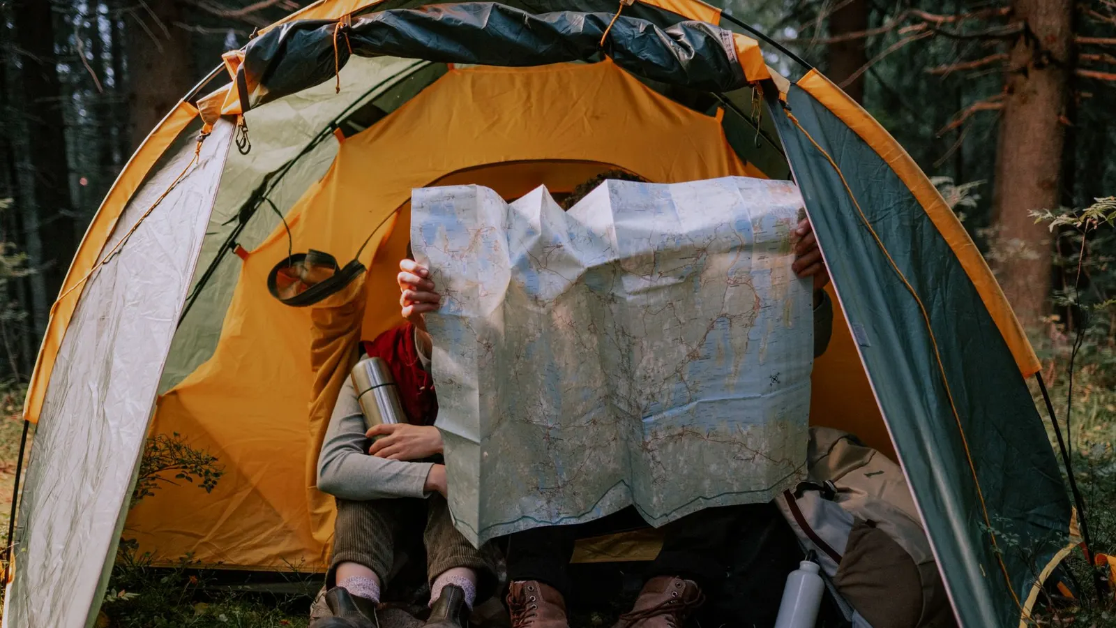 Reading a map inside a tent at camp