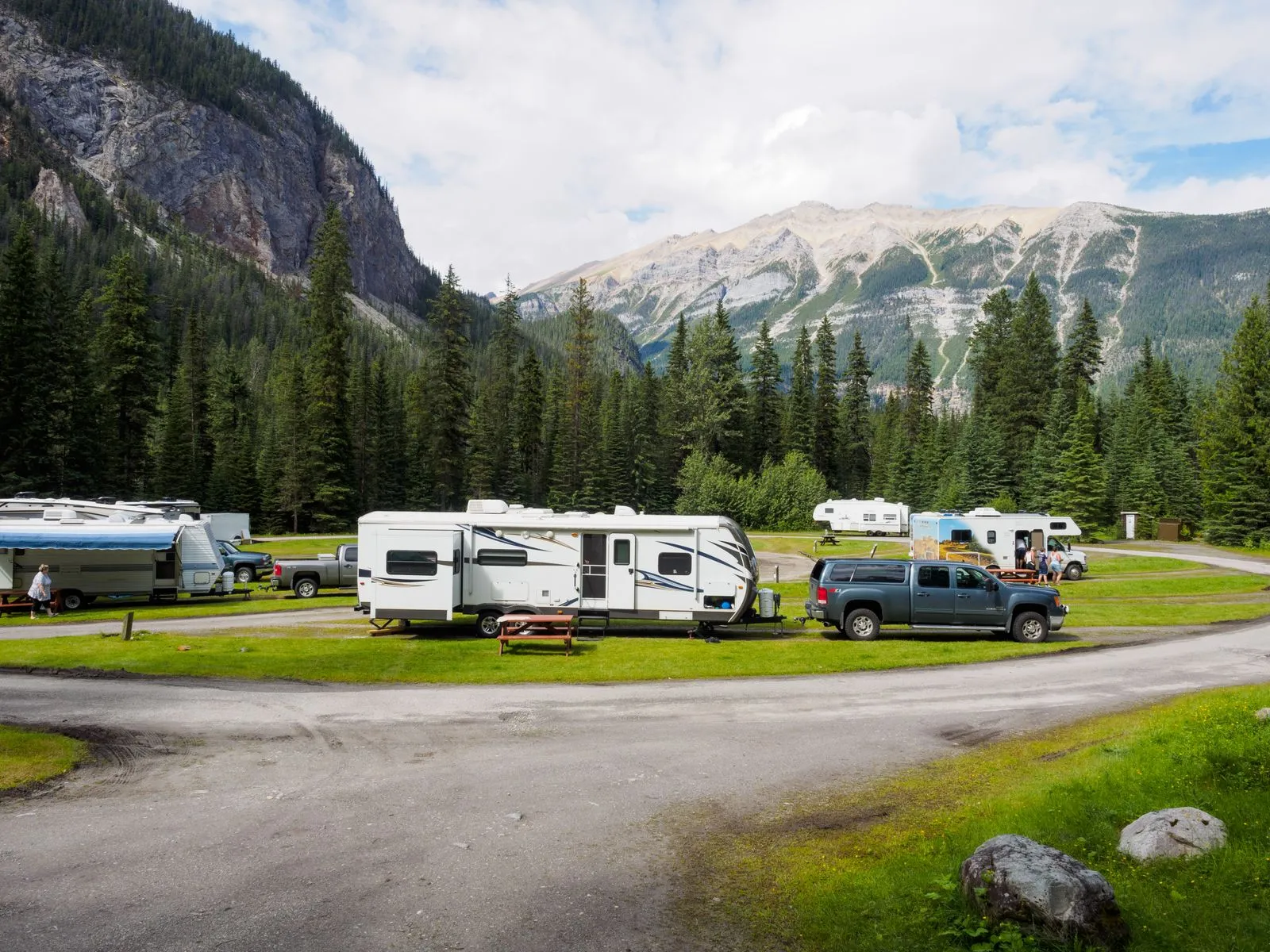 Travel trailers and RVs parked at a forested mountain campsite