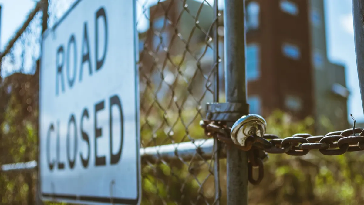 A closed gate across a forest road